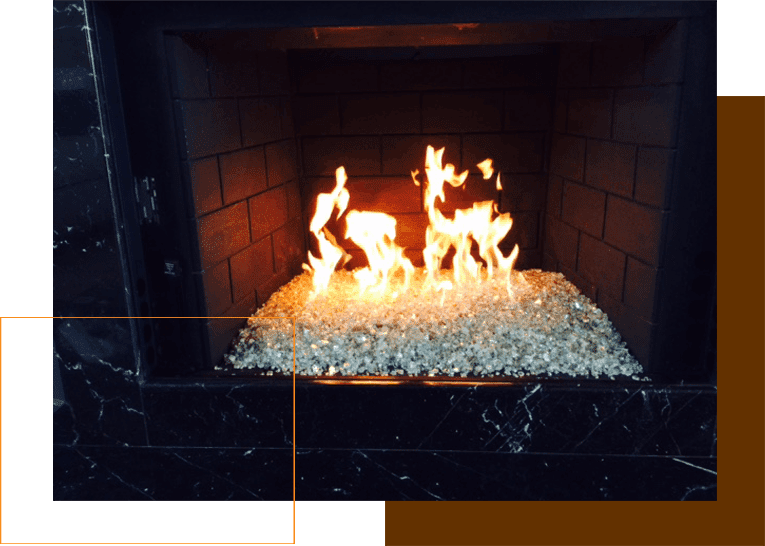 A fire place with white rocks and flames.